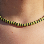 Electric Eel lime green & black heishi necklace close up detailed view on model's neck