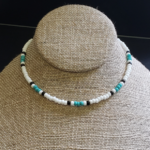 Sea Sprite Necklace is a single strand seed bead necklace with white, seafoam, & black beads in traditional pattern.