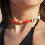 Volcanic Necklace of white, black, red, yellow, & turquoise heishi beads in a detailed view on model's neck.