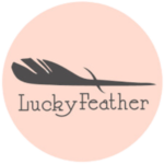 Lucky Feather Logo in black with feather on top of company name. Logo inside pink circle.