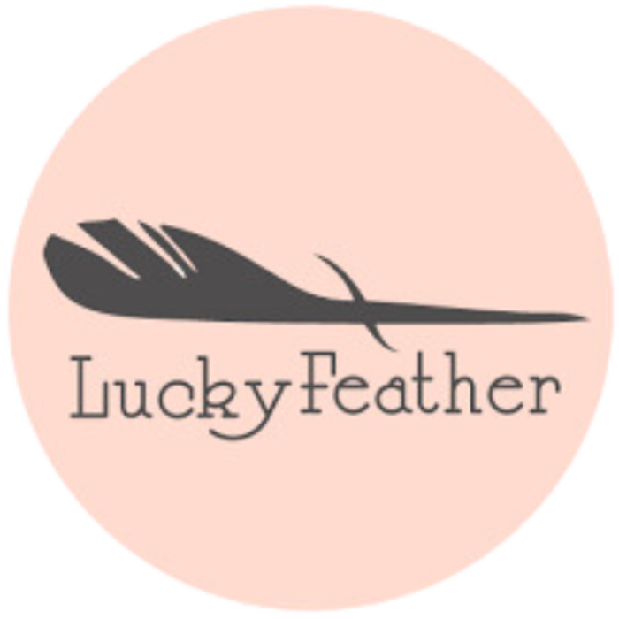 Lucky Feather Logo in black with feather on top of company name. Logo inside pink circle.