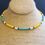 Tropical Sun is a single strand, minimalist seed bead necklace designed with yellow, seafoam, black, and white seed beads. Displayed on jewelry bust.