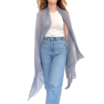 The Boho Shawl in light gray on model wearing jeans and white t-shrit in front of white background.