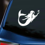 Mermaid Seastar Vinyl Decal white decal of long haired mermaid cupping a starfish in her outstretched hand displayed on back window of blue car with dark tinting.