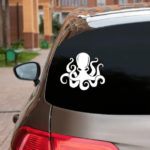 Octopus Vinyl Decal white decal displayed on back window of silver hatchback car with dark tinting.