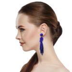 Navy Beaded Knot Post Statement Earrings shown on profile of model with brown hair in ponytail. Post earring is made with navy seed and bugle beads and is in a knot pattern with beaded fringe hanging down below the knot.