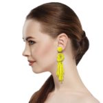 Beaded Post Statement Earrings Yellow shown on profile of model with brown hair in ponytail. Post earring is made with seafoam seed and bugle beads and is in a knot pattern with beaded fringe hanging down below the knot.